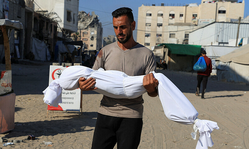 A man carries the body of a child during the funeral of Palestinians, who, according to Gaza’s health ministry, were killed in an Israeli air strike on a house, outside Al-Shifa Hospital, in Gaza City on June 25, 2025. — Reuters