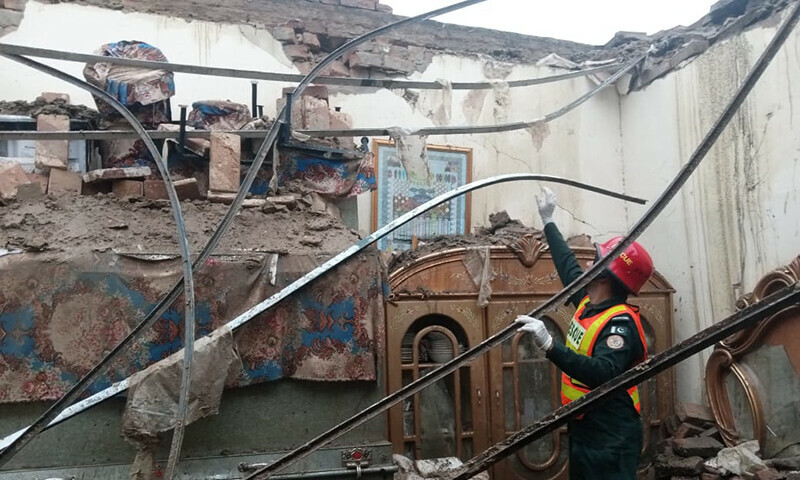 A rescuer examines the ruins of a collapsed house in Kasur on June 26. &mdash; Rescue 1122