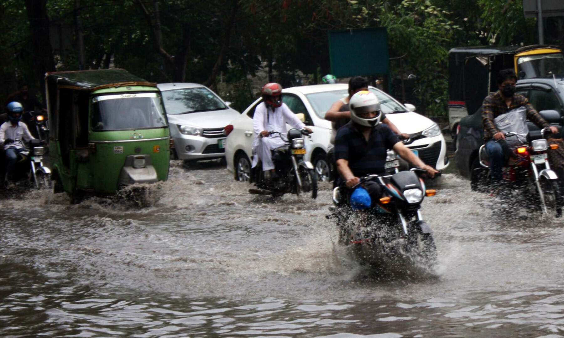 Commuters travel in stagnant rainwater after heavy downpour during monsoon season, near US Consulate in Lahore on June 27, 2025. &mdash; Babar Shah/PPI Images