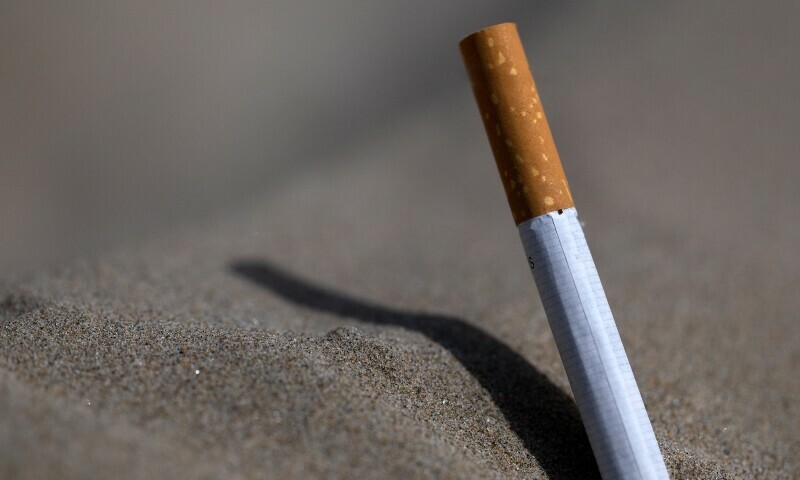 This photograph shows a cigarette on a beach in Saint-Nic, western France, on June 24. &mdash; AFP