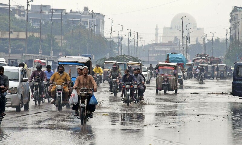Motorists on their way at a road after the heavy rain in Karachi on June 27. — Online photo by Sabir Mazhar