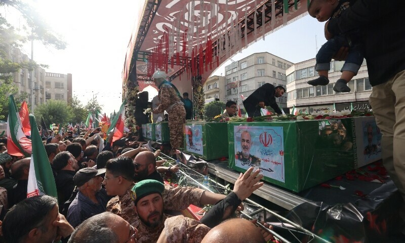 A mourner reaches out to touch the coffin of Iranian Islamic Revolutionary Guard Corps (IRGC) commander Hossein Salami (C), and other military commanders killed in Israeli strikes on Iran, during their funeral procession at Enghelab (Revolution) Square in the capital Tehran on June 28. — AFP