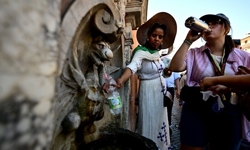 People fill their bottle at a fountain on a hot summer day in Rome near the Vatican on June 28. &mdash; AFP