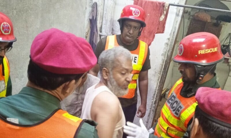 A rescue team assists one of the injured after the roof of a house collapsed due to heavy rain near Lal Haveli in Rawalpindi. &mdash; photo by the author