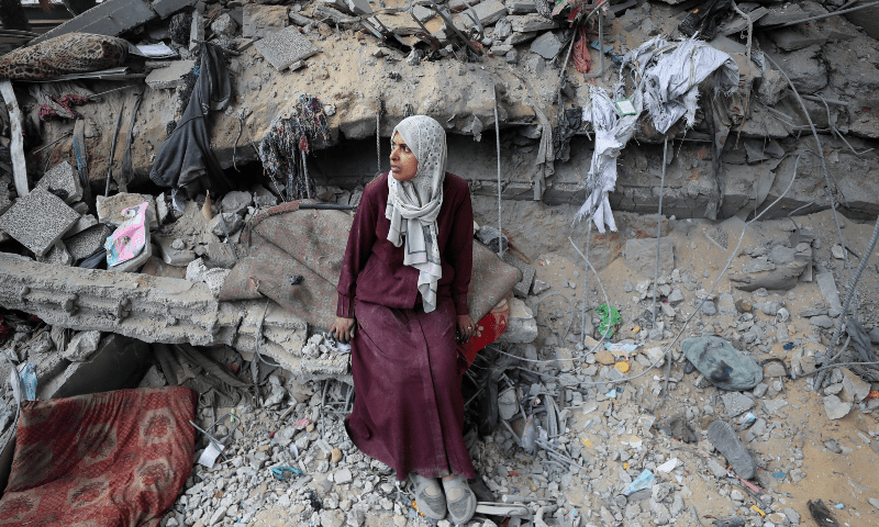 A Palestinian woman sits amidst the damage at an UNRWA school sheltering displaced people that was hit in an Israeli air strike on Sunday, in Gaza City on June 30, 2025. &mdash; Reuters