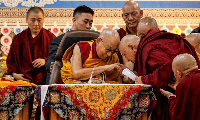 Tibetan spiritual leader the Dalai Lama (C) blesses a Buddhist monk during a Long Life Prayer offering ceremony at the Main Tibetan Temple in McLeod Ganj, near Dharamsala on June 30. &mdash; AFP