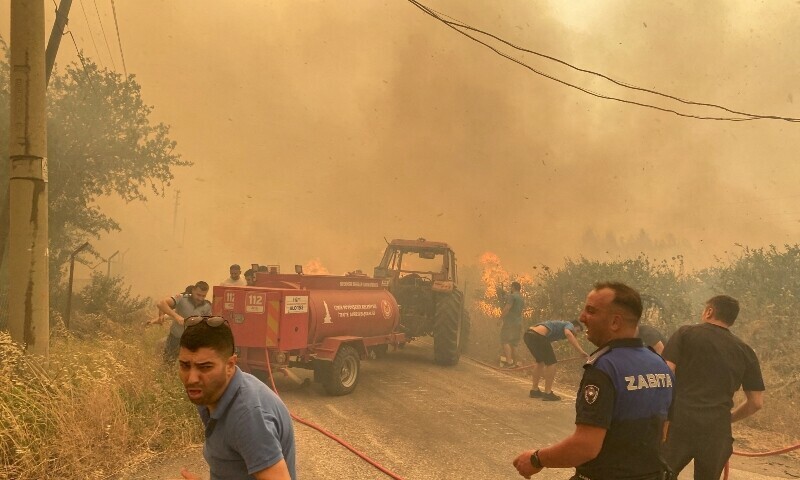 Firefighters and local residents respond to a wildfire in Menderes district of the Aegean city of Izmir, Turkiye, June 29. &mdash; Reuters