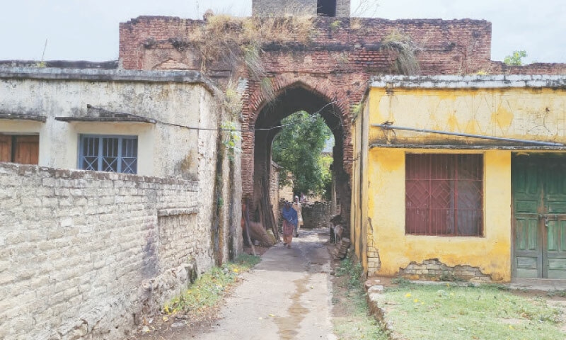 An elderly man and woman walk through a street inside the Mughal-era roadside inn, Sarai Saadabad, in AJK&rsquo;s Samahni Valley on Saturday. &mdash; Dawn