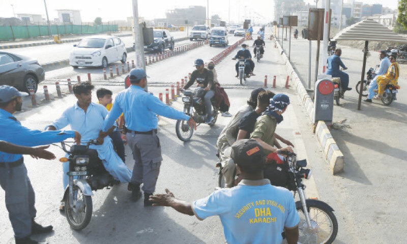 DHA Vigilance personnel stop motorcyclists without helmets from proceeding toward Do Darya in DHA Phase 8.&mdash;Shakil Adil / White Star