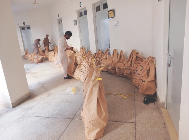 GUJRAT: An official seals the bags carrying ballot papers for shifting the same to Gujranwala regional office of the ECP. &mdash; Dawn