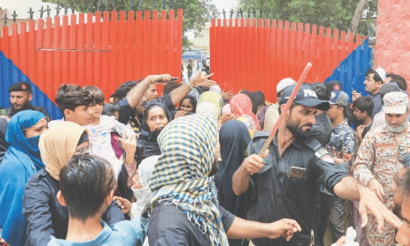 A policeman with a baton disperses family members of prisoners, who had gathered outside Malir district jail to gather information about their loved ones.&mdash;Reuters