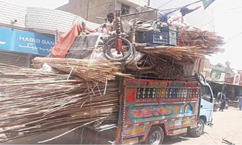 SITTING over their ramshackle belongings, a coastal family arrives in Sujawal in search of better life.—Photo by the writer