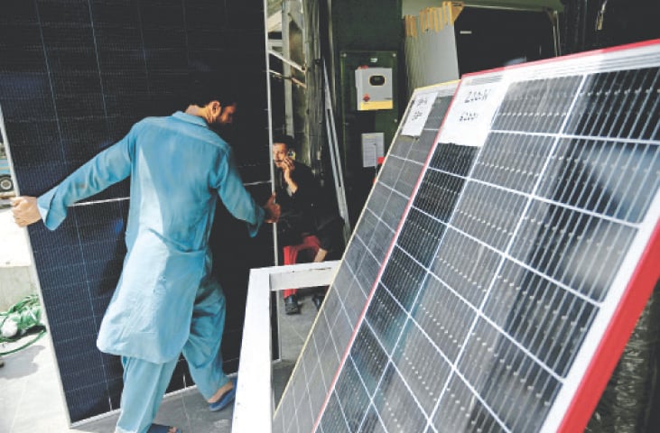  KARACHI: A worker at a shop arranges solar panels on Wednesday. According to Topline Securities, the country imported $2 billion worth of solar panels in FY24. The imposition of 18pc sales tax can easily fetch Rs100bn in revenues in FY26, assuming a same run rate of imports.—AFP 