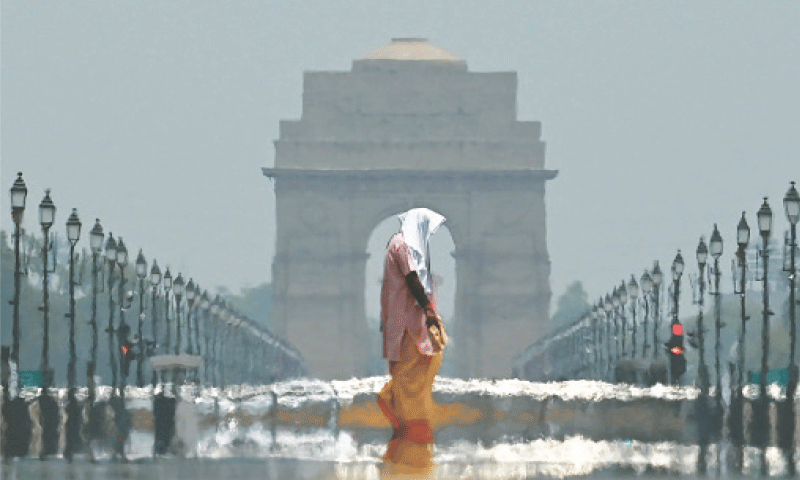A WOMAN wearing a scarf walks past the India Gate on a hot summer day in the Indian capital.—AFP