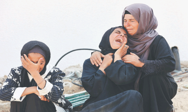 Women mourn the death of a loved one in overnight Israeli bombardment at the Al Shifa hospital. —AFP