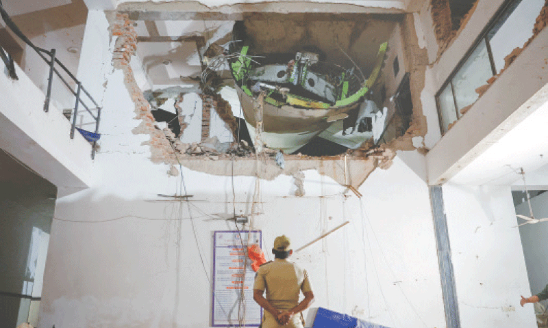 A police officer looks at debris from a Boeing 787 Dreamliner, lodged in a residential building in the Indian city of Ahmedabad. The Air India flight to London crashed seconds after takeoff, killing over 200 people on board.—Reuters