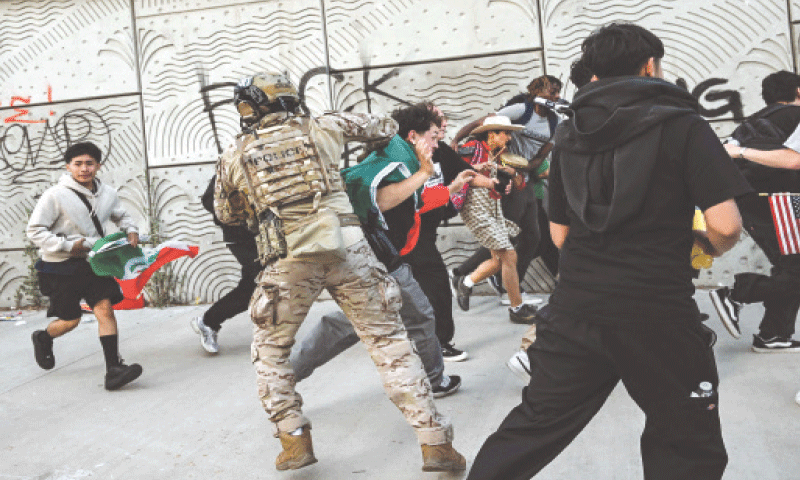 CUSTOMS and border protection agents disperse protesters outside a federal building in Los Angeles.&mdash;AFP