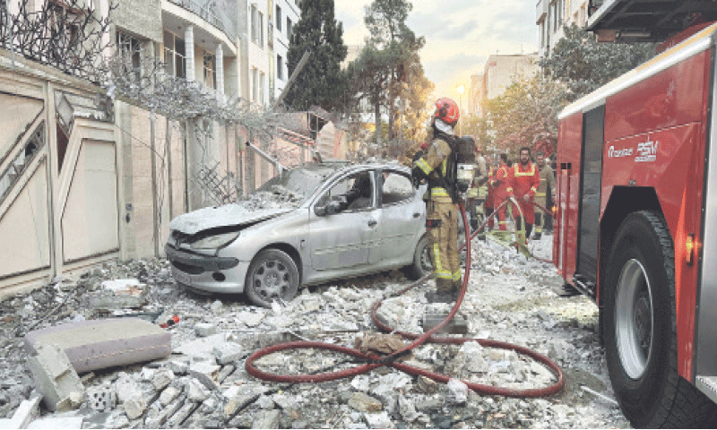 TEHRAN: First responders gather outside a building, hit by an Israeli strike in the early hours of Friday.—AFP