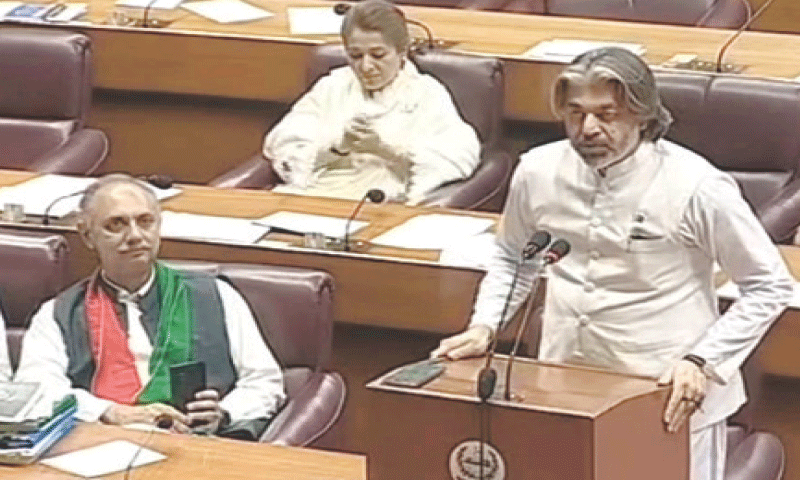 PTI’s Ali Muhammad Khan speaks from a special dais at the opposition leader’s seat, as Omar Ayub films him.—Screengrab