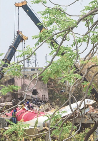 A crane removes the aeroplane&rsquo;s tail from the wreckage in a residential area near the airport on Saturday.&mdash;AFP