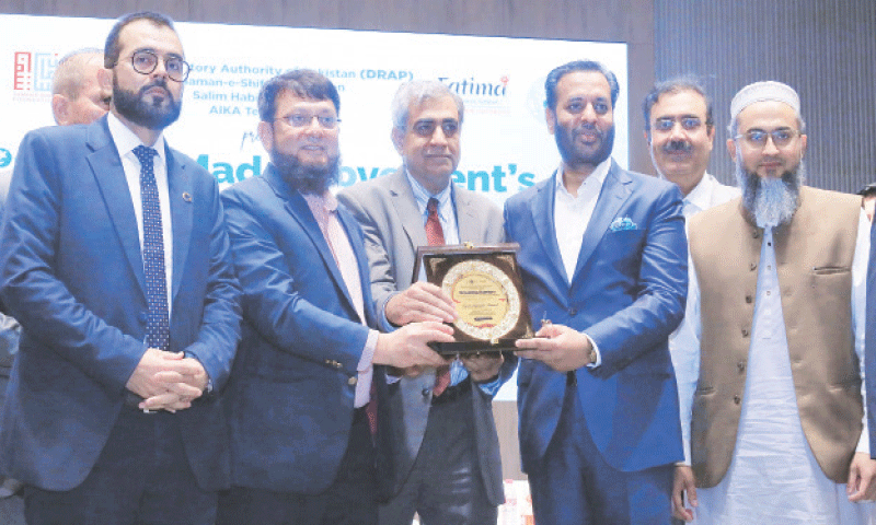Federal Health Minister Mustafa Kamal is presented a shield at the conference.—Dawn