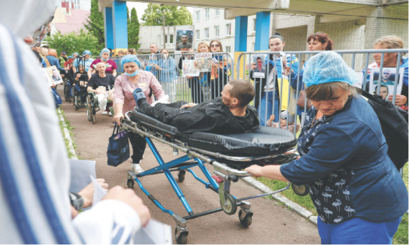 Medical workers assist injured Ukrainian prisoners of war after a swap in an undisclosed location on Saturday.—Reuters