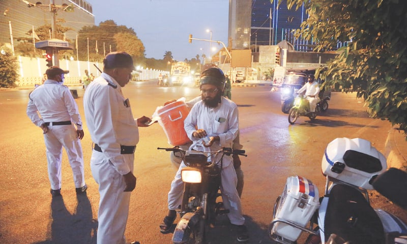 Traffic police stop a motorcyclist near the PIDC intersection.&mdash;Shakil Adil / White Star