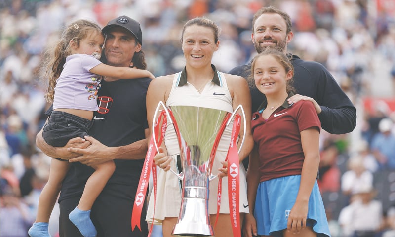 GERMANY’S Tatjana Maria poses with the trophy as she celebrates with her husband Charles-Edouard Maria (L) and daughters Charlotte and Cecilia after winning the Queen’s Club Championships final against Amanda Anisimova of the US at Queen’s Club on Sunday.—Reuters
