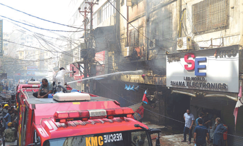 Firefighters hose down the burning building in the electronics market.&mdash;PPI