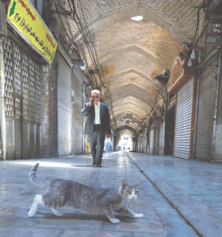  A man walks past closed shops in Tehran’s Grand Bazaar on Monday. The city’s largest and most prominent marketplace was closed as fighting between Israel and Iran entered a fourth day. The main gate was shut, with streets largely deserted and most shops across the capital closed, except for a few grocery stores.—AFP 