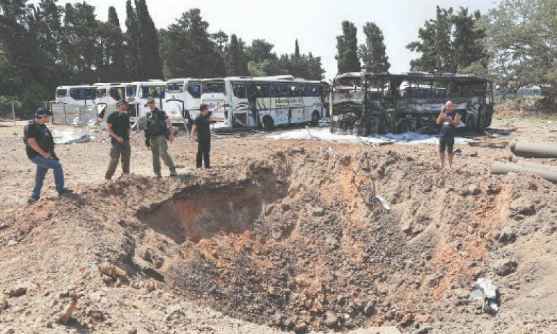 Herzliya (Israel): Policemen stand next to an impact crater following an Iranian attack in this coastal town on the outskirts of Tel Aviv, frequented by those wishing to leave by boat.—Reuters