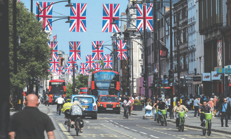 CARS and cyclists move about on London’s Oxford Street.—Reuters