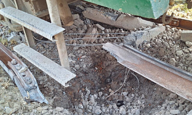 A SMALL crater is visible under the train with broken pieces of the track lying nearby.—Photo by the writer