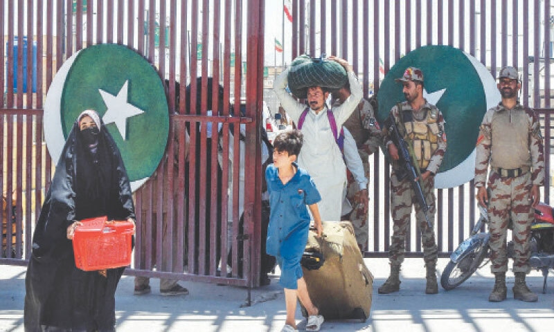Pakistani pilgrims walk across the Pakistan-Iran border at Taftan.—AFP