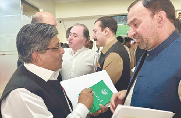 PTI’s Chaudhry Rafique Nayyar (left) confronts Law Minister Abdul Waheed at the entrance to the assembly hall in Muzaffarabad.—Photo by the writer