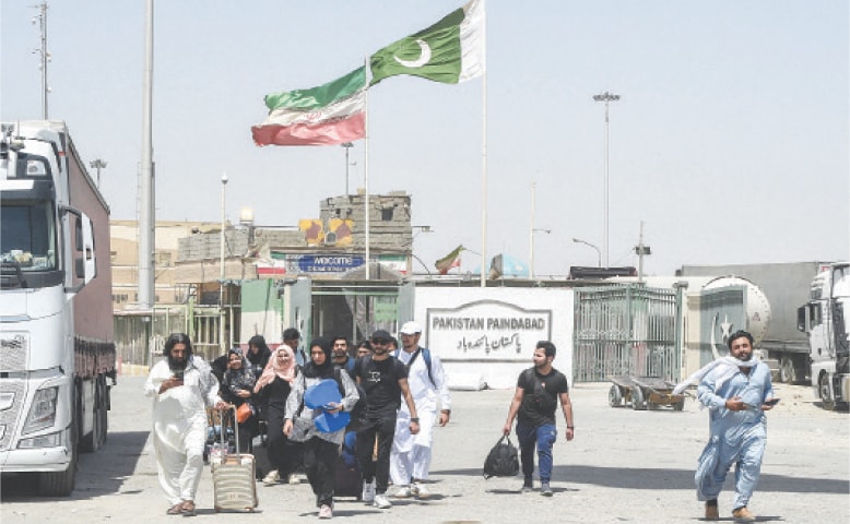 TAFTAN: Returning Pakistani students cross the border.&mdash;AFP