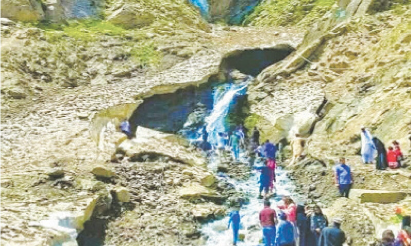 Visitors look at the portion of Sohni glacier that collapsed burying three members of a family alive near Naran in Kaghan Valley on Friday. — Photo by Nisar Ahmad Khan