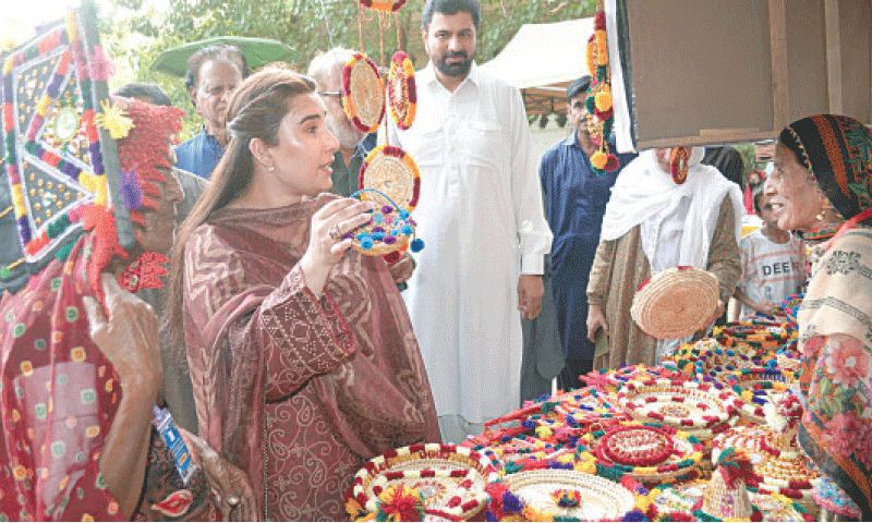 VISITORS engage with a craftswoman at a stall.&mdash;Photo By Umair Ali