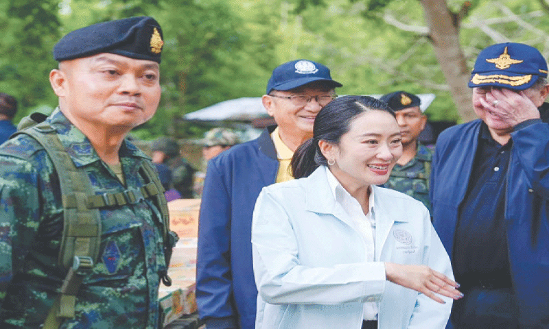 Thai Prime Minister Paetongtarn Shinawatra (second right) stands next to General Boonsin Padklang, 
whom she disparaged in a phone call with Cambodian leader Hun Sen, during a visit to a military base 
on Friday.&mdash;AFP