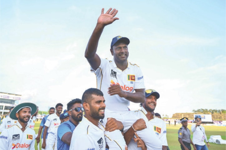  GALLE: Sri Lanka’s Angelo Mathews gestures as he is carried around the field by team-mates at the end of the first Test against Bangladesh at the Galle International Cricket Stadium on Saturday. Mathews, who made his debut in 2009 on the famous pitch perched beneath the fortress in Galle in 2009, will hang up his boots with over 8,000 runs, after playing his 119th and final Test, behind only Kumar Sangakkara and Mahela Jayawardene in Sri Lanka’s all-time charts.—AFP 