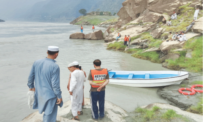 Rescuers and local volunteers search for bodies of two girls who drowned in Indus River in Torghar on Sunday. &mdash; Dawn
