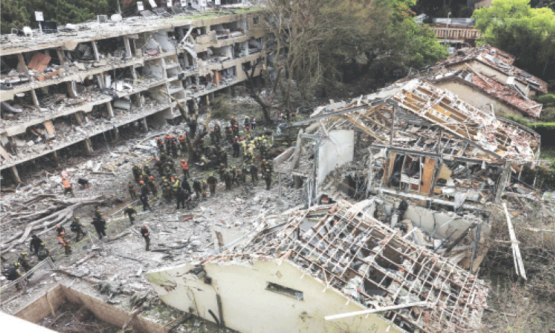 Tel Aviv: Rescuers and security personnel work 
at a site after a missile attack from Iran.&mdash;Reuters