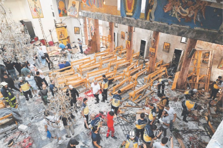 People and rescuers inspect the damage at the site of a suicide attack at the Saint Elias church in Damascus’ Dwelaa area on Sunday.—AFP
