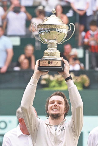 Kazakhstan’s Alexander Bublik lifts the trophy after beating Russia’s Daniil Medvedev in the Halle Open final on Sunday.—AFP