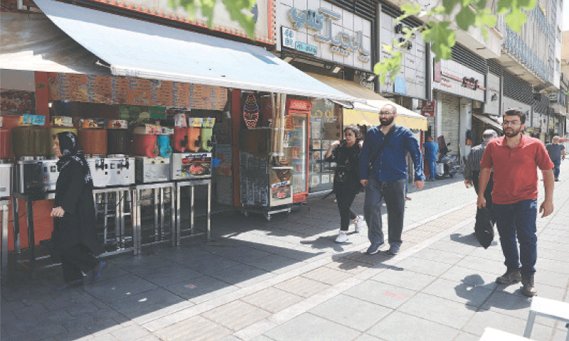 TEHRAN: People walk on a street during early hours of the ceasefire on Tuesday.&mdash;Reuters