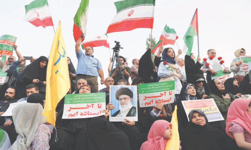 TEHRAN: People attend a demonstration in support of Iran’s armed forces following President Donald Trump’s announcement of a ceasefire with Israel.—Reuters