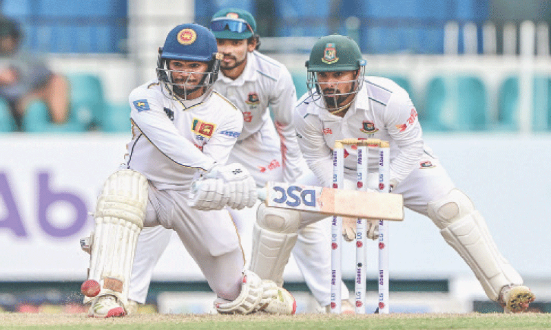 SRI LANKAN opener Pathum Nissanka prepares to play a reverse sweep as Bangladesh wicket-keeper Liton Das looks on during the second Test at the Sinhalese Sports Club ground on Thursday.—AFP SRI LANKAN opener Pathum Nissanka prepares to play a reverse sweep as Bangladesh wicket-keeper Liton Das looks on during the second Test at the Sinhalese Sports Club ground on Thursday.—AFP