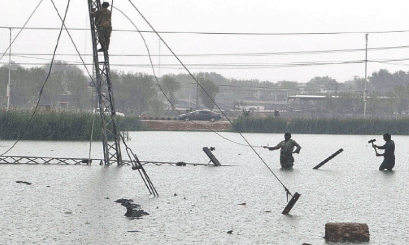 STAFF of the Hyderabad Electric Supply Company working to fix the cables fallen down from a pylon hooked to the Sarfaraz  Baba Feeder during rain.&mdash;PPI