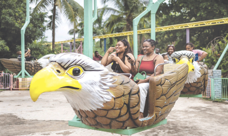 Abuja (Nigeria): Amusement park visitors ride a bird-shaped carousel at Magic Land.&mdash;AFP