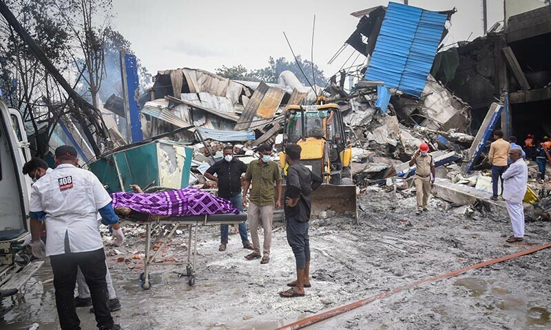 Emergency personnel stand near a casualty on a strecher, after an explosion and fire at a chemical factory, in Sangareddy, in the southern state of Telangana, India on June 30. — Reuters